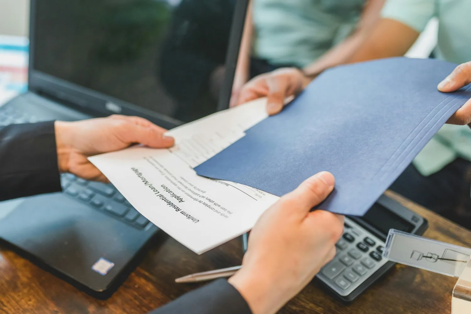 Partenaire administratif à domicile Image montrant un homme qui prend un dossier contenant un document, ce dossier est donné par un couple.